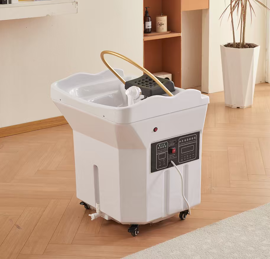 White mobile pedicure foot spa with basin, hose, and control panel on caster wheels in a salon setting with wooden floor and a plant nearby