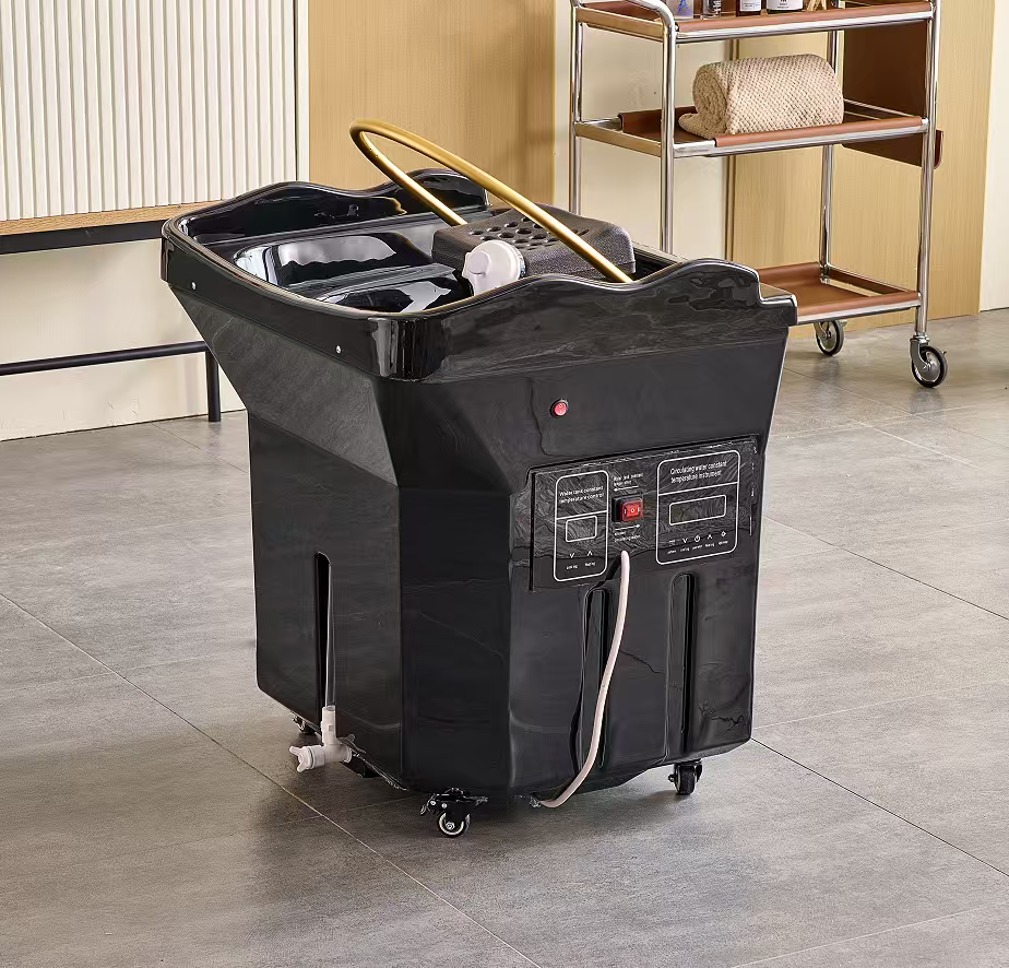 Black rolling pedicure spa foot bath with control panel and hoses in a salon treatment room.